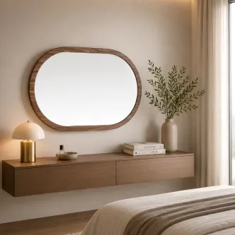 Espelho oval com moldura de madeira refletindo janela e vegetação exterior