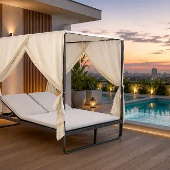 Espreguiçadeira dupla com cortina branca junto à piscina ao pôr do sol