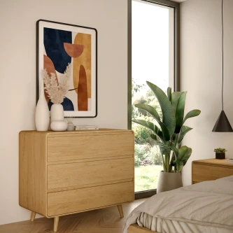 Cómoda Tivoli com pés em madeira clara junto a janela, com vaso e quadro abstrato