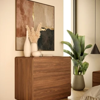 Cómoda Tivoli em madeira com três gavetas, vasos decorativos, quadro e planta