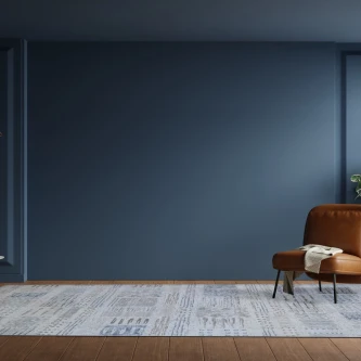 Tapete Drizzle cinzento com padrão abstrato em sala com parede azul e poltrona castanha