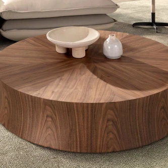 Mesa de centro Fiara redonda em nogueira com padrão radial, tigela e vaso brancos.