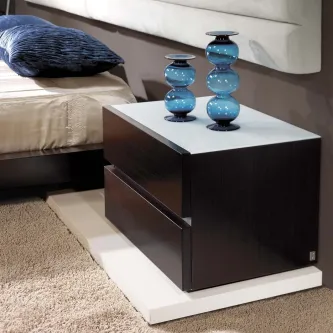 Mesa de cabeceira escura com tampo branco e dois vasos azuis