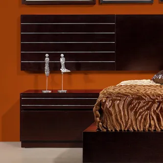 Mesa de cabeceira 15 Porto em madeira escura junto a cama com objetos decorativos