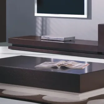 Mesa de centro Sette em madeira escura com tampo baixo e revista aberta.