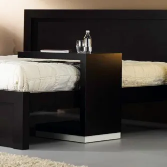 Tabuleiro de cama negro entre duas camas com garrafa, copo e livro