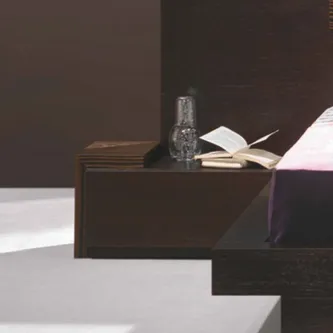 Mesa de cabeceira mm em madeira escura com garrafa de vidro e livros