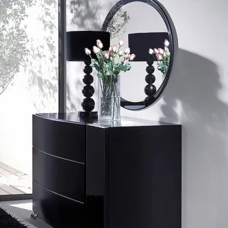 Cômoda com espelho circular e vaso de flores rosas