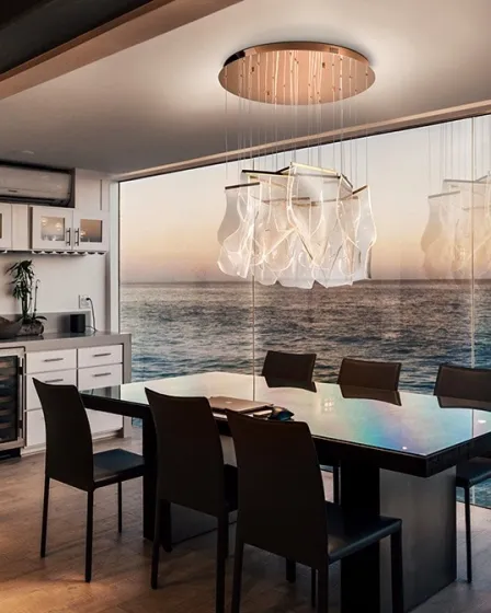 Candeeiro de teto Velos com placas translúcidas sobre mesa de jantar e vista para o mar