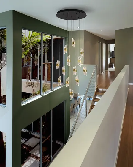 Candeeiro de teto Iliada 13L com 13 pendentes de vidro em cascata sobre escadas