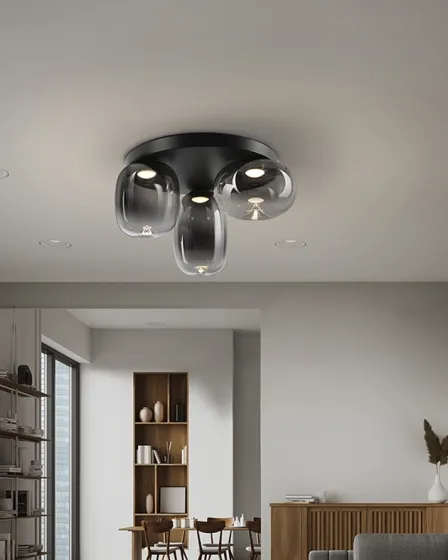 Plafon Onice preto com três globos de vidro transparente montado no tecto sobre sala de jantar