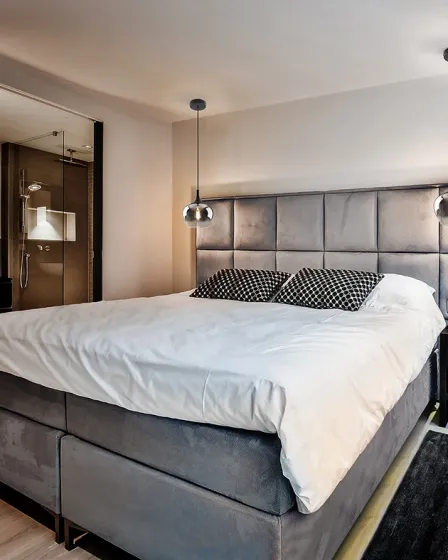 Candeeiro suspenso Opaz, dois globos de vidro fumado sobre cabeceira acolchoada