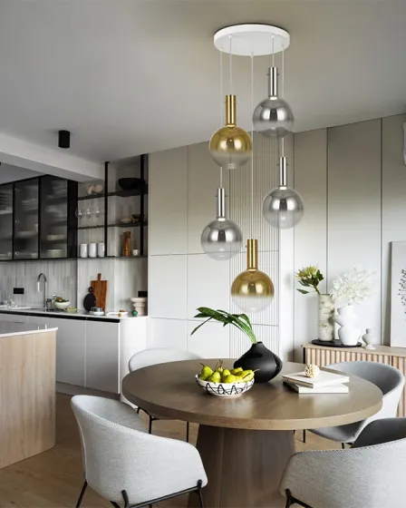 Candeeiro de teto Matices com esferas metálicas douradas e prateadas sobre mesa de jantar