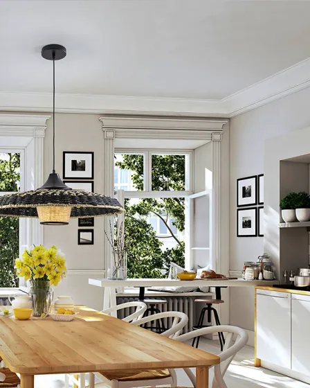Candeeiro suspenso Fiji em rattan sobre mesa de madeira numa cozinha luminosa