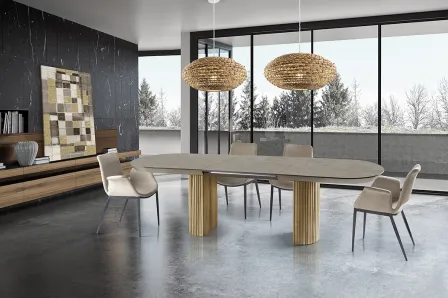 Mesa extensível Irati em madeira com tampo oval, cadeiras e candeeiros numa sala