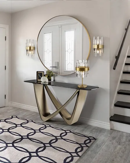 Consola Genesis dourada com tampo preto e espelho circular num hall