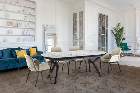 Mesa extensível Antea com tampo marmoreado e seis cadeiras numa sala luminosa