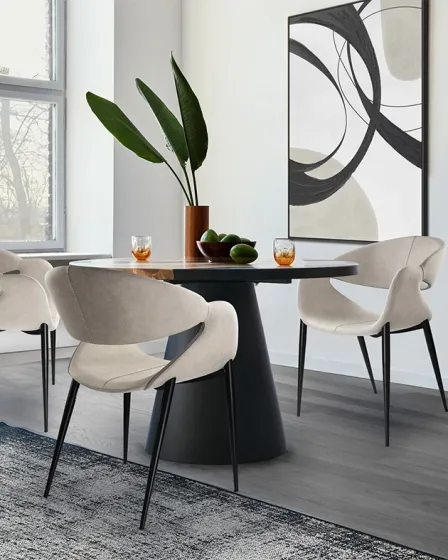 Cadeira giro branca giratória com pernas pretas junto a mesa de jantar redonda