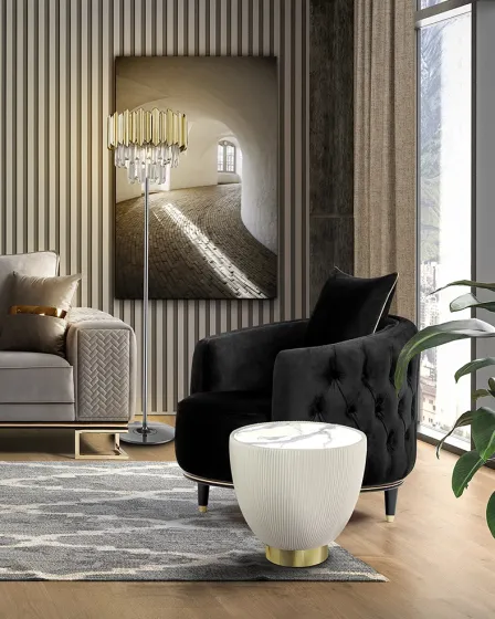 Mesa de apoio Candy branca com textura em relevo e base dourada junto a poltrona preta