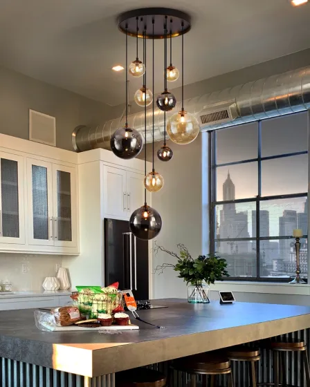 Candeeiro com nove globos de vidro suspensos sobre ilha de cozinha moderna