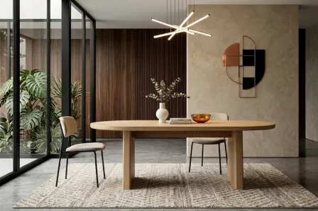 Mesa oval Blair em madeira clara com cadeiras e candeeiro moderno.