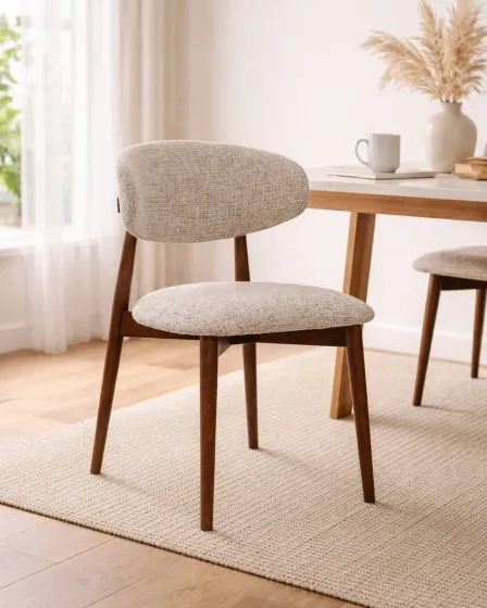 Cadeira Roya estofada bege com pernas em madeira junto a mesa de jantar