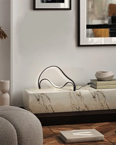 Candeeiro de mesa Danza PQ metálico em forma ondulada sobre consola de mármore