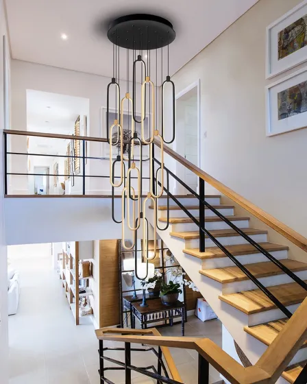 Candeeiro de teto Colette XXL com anéis dourados suspenso em hall de escadas moderno