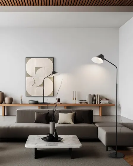 Candeeiro de pé esino preto junto a sofá cinzento em sala minimalista