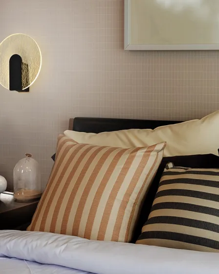 Aplique Auris redondo com anel luminoso junto a cabeceira de cama