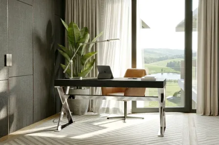 Secretária Vitre em vidro com pés cromados, cadeira castanha e planta junto à janela