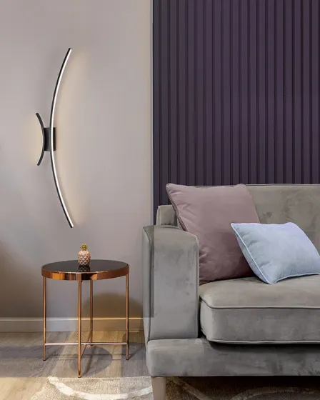 Aplique Curves curvo em LED na parede junto a sofá cinzento e mesa lateral