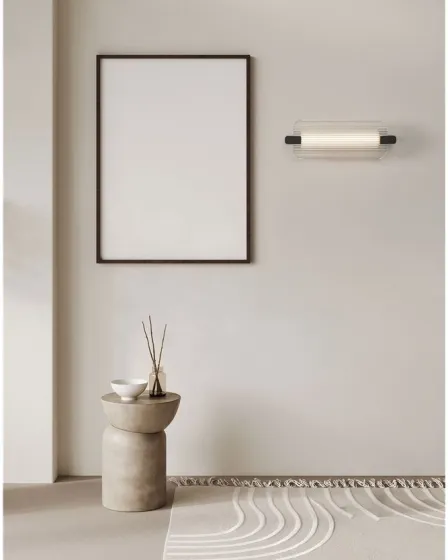 Aplique Emery branco com extremos pretos montado na parede acima de pedestal decorativo