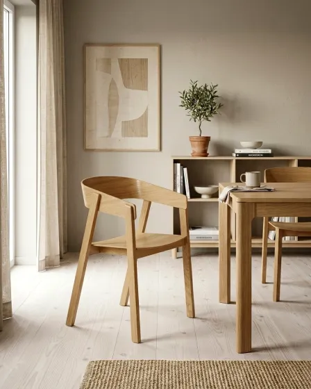 Cadeirão Cuvo Vitaro em madeira clara junto a mesa de jantar, ambiente minimalista