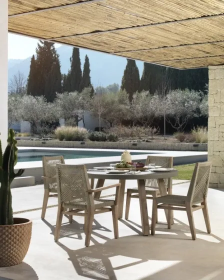 Cadeirão de jardim Croci em rattan sintético ao lado de mesa junto à piscina