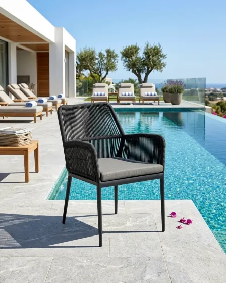 Cadeirão de jardim tonda preto com assento almofadado cinzento junto à piscina