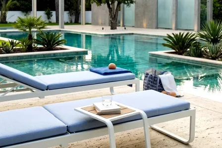 Mesa de apoio jardim Cires branca junto a espreguiçadeira à beira da piscina