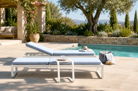 Espreguiçadeira Cires azul-claro almofadada junto a piscina com mesa lateral e chapéu