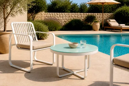 Mesa centro redonda de jardim Cires entre duas cadeiras rattan junto à piscina