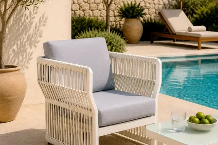 Poltrona de jardim Cires branca com almofada cinzenta junto à piscina
