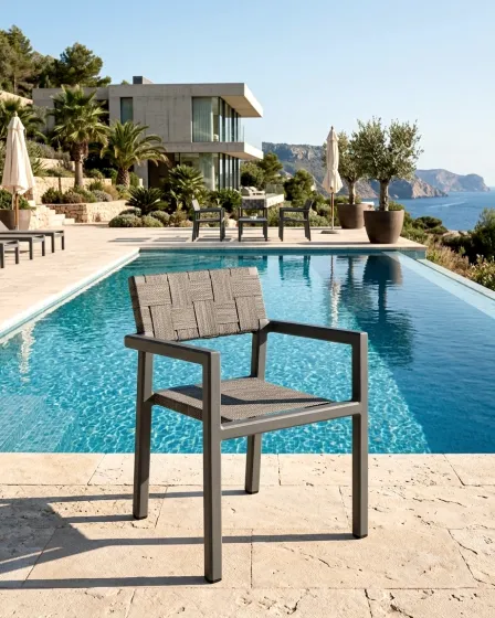 Cadeira de jardim com braços Cube cinzenta junto à piscina com vista mar
