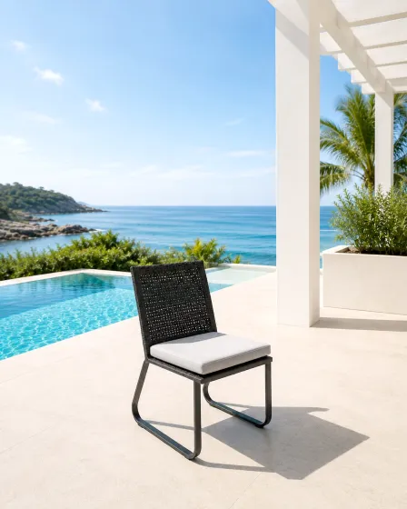 Cadeira de jardim Star preta com almofada branca junto à piscina e mar ao fundo