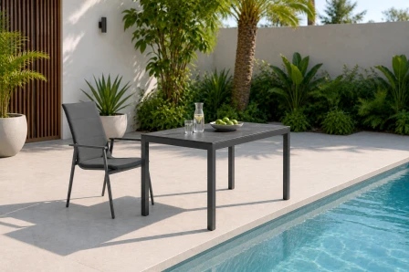 Mesa de jardim Soffice cinzenta junto à piscina com jarra e tigela de limas