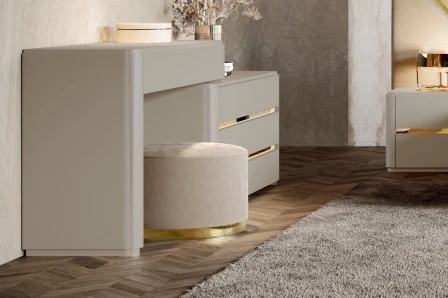 Puff Alma New redondo bege com base dourada sob cómoda em ambiente moderno