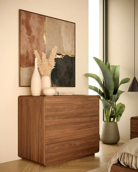 Cómoda Tivoli em madeira com três gavetas, vasos decorativos, quadro e planta
