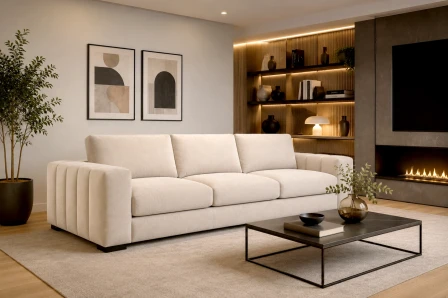 Sofá de três lugares Novila creme numa sala moderna com mesa de centro e prateleiras iluminadas