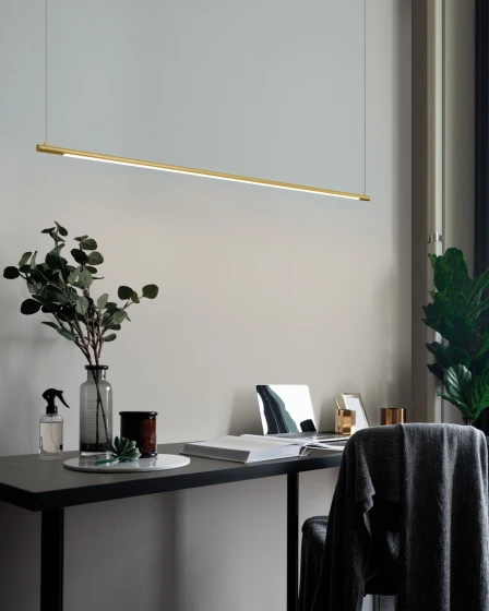 Candeeiro de teto Elettra Line linear dourado suspenso sobre secretária moderna
