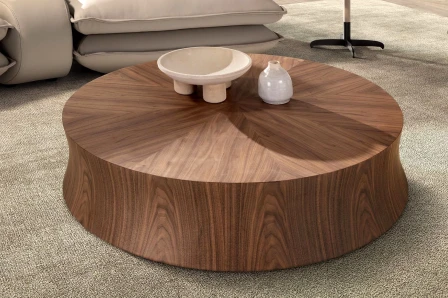 Mesa de centro Fiara redonda em nogueira com padrão radial, tigela e vaso brancos.