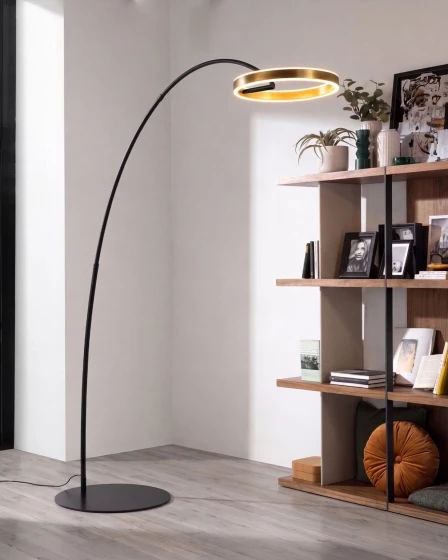 Candeeiro de chão Numi arqueado com anel luminoso dourado junto a estante
