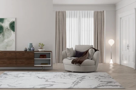 Tapete Storm branco e cinzento com padrão mármore numa sala com poltrona redonda